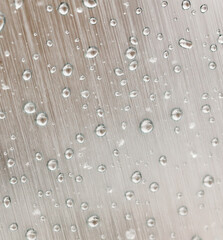 A silver surface with a pattern of small, clear droplets