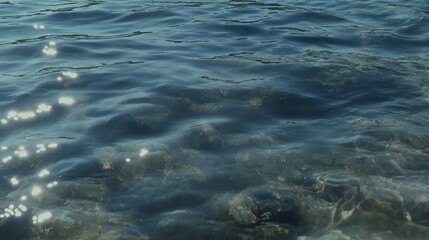 Tranquil Blue Water With Sparkling Sunlight And Visible Rocks