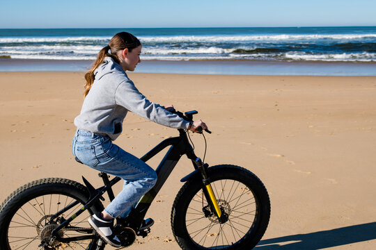 Generated imaBeautiful young girl riding an electric fat bike with her dog.ge