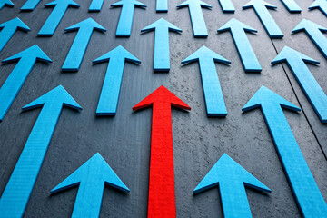 Red Arrow Pointing Up Among Blue Arrows Representing Leadership and Uniqueness in Business