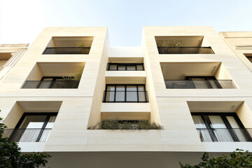 Obraz premium Modern architectural design of a multi-story building with balconies in an urban setting