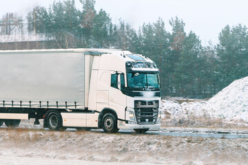 Industrial semi-truck driving on icy road