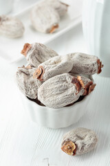 Dried persimmons on a white wooden table.