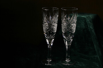 Two faceted crystal glasses on high stems on a dark background. Bohemian glass from the USSR.