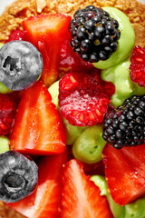 A vibrant and refreshing mille-feuille dessert, layered with fresh berries and a light cream. The dessert is garnished with a sprig of mint, creating a visually appealing and appetizing composition