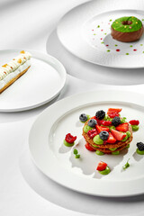 A trio of elegant desserts featuring a variety of flavors and textures. Each dessert is beautifully presented on individual plates, creating a visually appealing and appetizing composition.