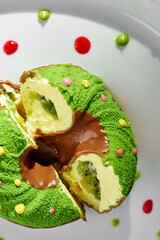 A whimsical and colorful dessert donut is displayed on a pristine white plate.