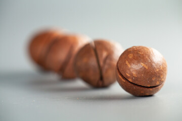 Close-up shot of a cluster of macadamia nuts, showcasing their natural beauty and texture. Nuts are...