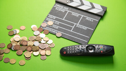TV remote controller and movie clapper board on the green background.