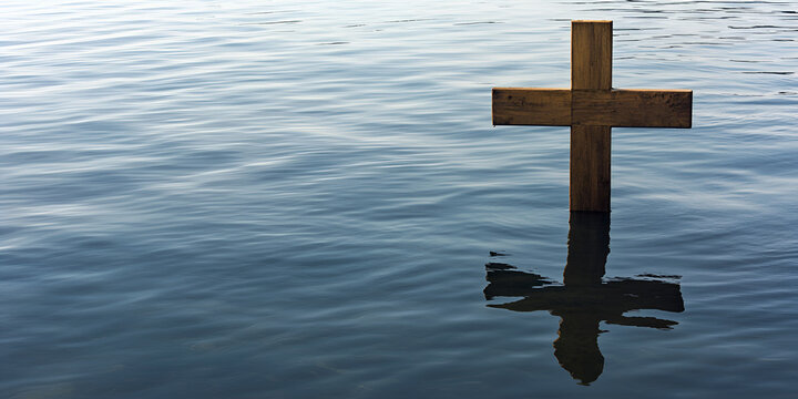 Wooden Cross in Water: A rustic wooden cross stands partially submerged in calm water, its reflection mirrored on the surface, creating a serene and contemplative scene.  