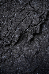 Vertical dark grey stone texture. Close up of rock wall. Black grunge surface with cracks. Granite. Slab. Nature Background. Copy space. 
