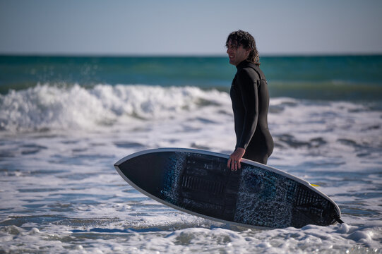 Surfer walking in the ocean with surfboard