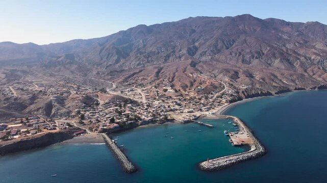 Coastal aerial view of Cedros Island, showcasing rocky terrain, blue waters, and dramatic landscapes, establishing panoramic