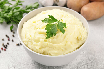 Mashed potatoes in white bowl on grey concrete background. Healt