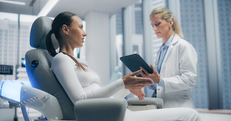 Female Doctor Consults With Female Patient in a Futuristic Medical Laboratory Clinic, Discussing...