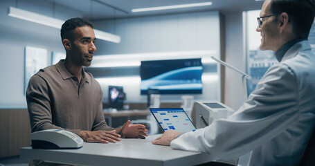 Specialist Physician Discusses Health Data With a Male Patient in a High-tech Medical Lab, Utilizing Advanced Equipment and Digital Tools for Precise Analysis in a Modern Hospital Setting