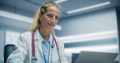 Portrait of a Female Physician Working on a Laptop Computer in a High-tech Hospital Office, Focusing on Medical Research and Patient Data Analysis in a Modern Clinical Setting