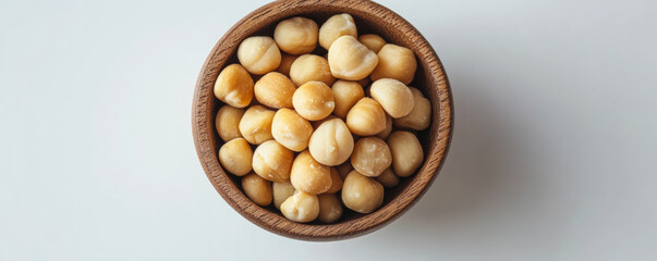 Close up view of macadamia nuts in wooden bowl, showcasing their creamy texture and natural color. Perfect for healthy snacking or culinary use