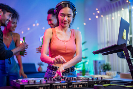 Asian young woman artist DJ mixing and scratching music mixer controller. 