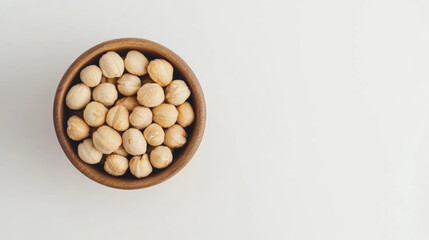 wooden bowl filled with macadamia nuts arranged neatly, showcasing their natural texture and color. This evokes sense of simplicity and health