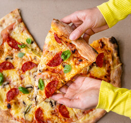 Slice of pizza in female hands top view photo