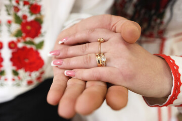 The groom puts a wedding ring on the bride's finger. Wedding ceremony.