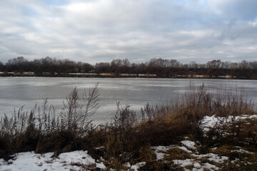 Frozen river bank on a cloudy day
