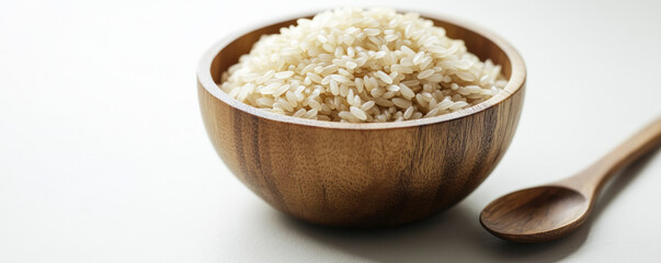 wooden bowl filled with uncooked rice grains, showcasing natural and rustic aesthetic. smooth texture of bowl complements rice, creating warm and inviting scene