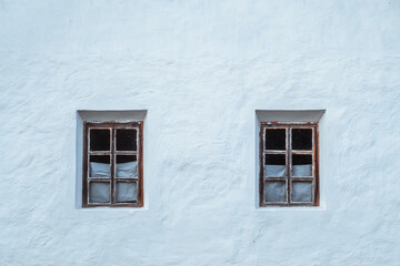 Minimalist aesthetic of two symmetrical windows of an old Ukrainian whitewashed house