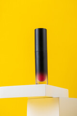 Mockup of black blank thin tube - mascara, lip gloss, gel, eyeliner, oil, etc. Cosmetic package with stylish props on yellow background.