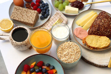 Assortment of various breakfast foods and drinks on the white table. Selective focus.
