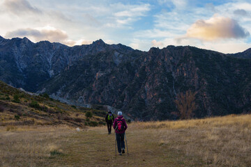 Hikers Walking on Mountain Trail at Sunset with Scenic Landscape