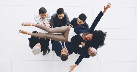 Celebration, lifting and throwing with business people in lobby of office from above for success....