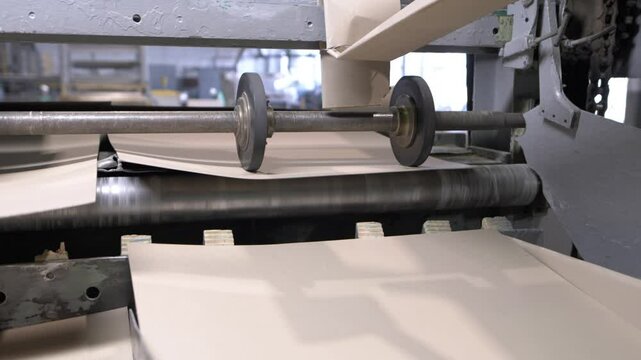 Production line with large cardboard leveling machine. Equipment effect material creating smooth final product for further packaging