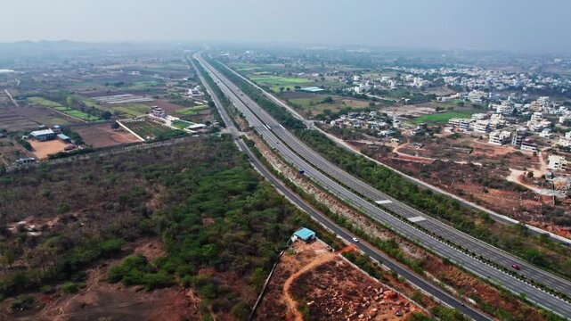 nehru outer ring road with residential buildings hyderabad, telangana. day time push back drone shot
