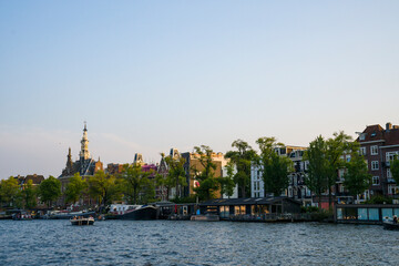 Naklejka premium Amsterdam Canal Houses at Golden Hour, Netherlands, Sunset Boat Tour on Amsterdam Canals, Historic Canal Ring District of Amsterdam in Summer