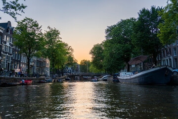 Obraz premium Amsterdam Canal Houses at Golden Hour, Netherlands, Sunset Boat Tour on Amsterdam Canals, Historic Canal Ring District of Amsterdam in Summer