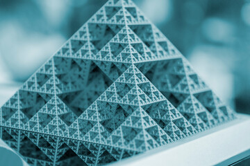 Small model of pyramid printed on 3D printer close-up. Object created on 3D printer from molten plastic. 3D printing technology. Additive modern new progressive technologies. FDM technology Blue color