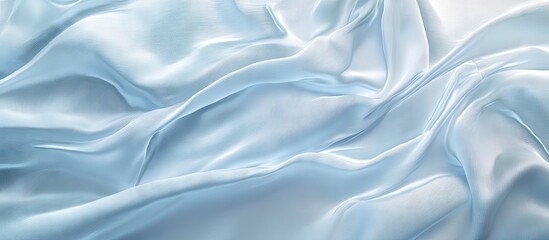 Obraz premium Silk fabric texture in soft light blue drapes elegantly on a smooth surface with gentle wrinkles highlighting its luxurious appeal and sheen