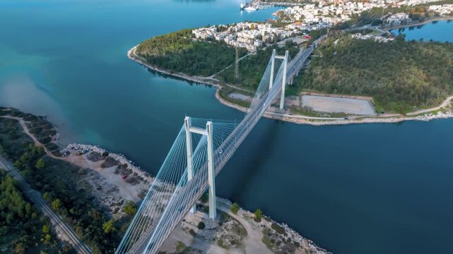 Aerial hyper time lapse view of the new Evripus suspension bridge between Euboea and mainland Greece with car traffic