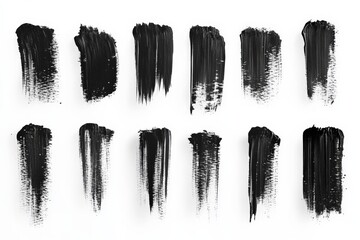 Various textures and strokes of black paint arranged on a white background showcasing artistic...