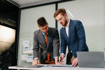 Diverse professionals collaborate on project analysis with financial graphs. Strategic teamwork and insights drive company growth and success.