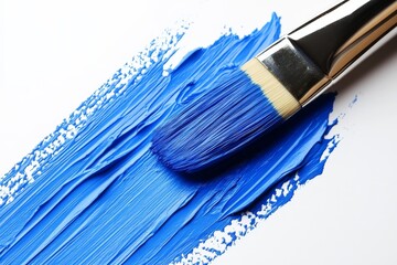 Fototapeta premium Vibrant blue paint applied with a brush on a blank canvas during a creative art project