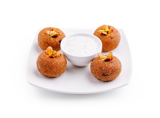 Delicious savory snacks served with creamy dipping sauce on a white plate at a festive gathering