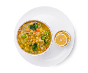 Delicious vegetable soup served in a bowl with lemon slices on the side