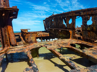 Rusted shipwreck remains of SS Maheno on Fraser Island 75 Mile Beach. Vibrant blue sky....