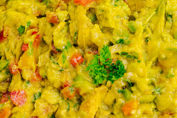 Guacamole prepared with fresh ingredients at a vibrant outdoor gathering in sunny weather