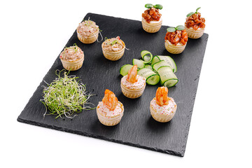 Creative gourmet appetizer display featuring mini pastry cups with various savory fillings and fresh garnishes