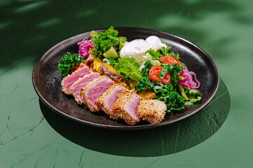 Freshly prepared seared tuna served with mixed greens and colorful vegetables on a stylish plate