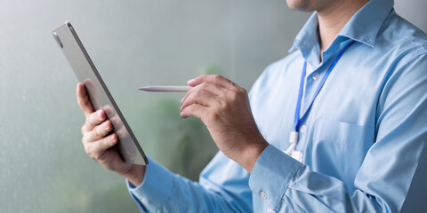 Business professional using a digital tablet with a stylus, showcasing innovation and technology in a modern office setting.
